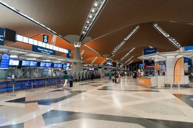 KUALA LUMPUR, MALAYSIA - 22 Kasım 2023: KLIA kontrol bölgesi. Kayıt işlemlerinde, havayolu personeli ile iletişim halinde olan yolcular belgelerini doğrulamak, bagajlarını kontrol etmek ve uçuş kartı almak için bulunurlar..