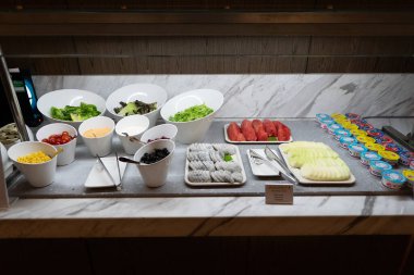 KUALA LUMPUR, MALAYSIA - NOVEMBER 22, 2023: Malezya Havayolları 'nın açık büfe alanında servis edilen salata malzemeleri ve meyve parçaları Yerel Altın Lounge, Kuala Lumpur Uluslararası Havalimanı (KLIA)).
