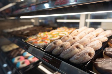 KUALA LUMPUR, MALAYSIA - 28 Kasım 2023: Donutlar Ampang Park MRT istasyonundaki Dunkin 'Donuts konteynır konsepti içinde cam bir vitrinde sergilendi.