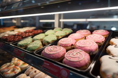 KUALA LUMPUR, MALAYSIA - 28 Kasım 2023: Donutlar Ampang Park MRT istasyonundaki Dunkin 'Donuts konteynır konsepti içinde cam bir vitrinde sergilendi.