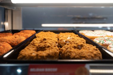 KUALA LUMPUR, MALAYSIA - 28 Kasım 2023: Donutlar Ampang Park MRT istasyonundaki Dunkin 'Donuts konteynır konsepti içinde cam bir vitrinde sergilendi.