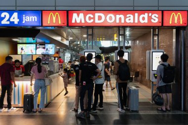 KUALA LUMPUR, MALAYSIA - 02 Aralık 2023: insanlar KL Sentral 'deki McDonald' s 'da kendi kendine sipariş veren büfeler kullanıyorlar. McDonald 's hamburgerleri, kızartmaları ve fast-servis yemekleriyle ünlü küresel bir fast-food zinciri..