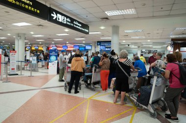 CHIANG MAI, THAILAND - 26 Ekim 2023: Chiang Mai Uluslararası Havalimanı 'ndaki kontrol gişesinde kuyrukta bekleyenler.