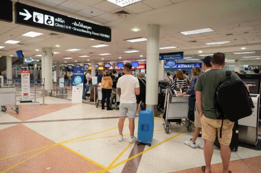 CHIANG MAI, THAILAND - 26 Ekim 2023: Chiang Mai Uluslararası Havalimanı 'ndaki kontrol gişesinde kuyrukta bekleyenler.