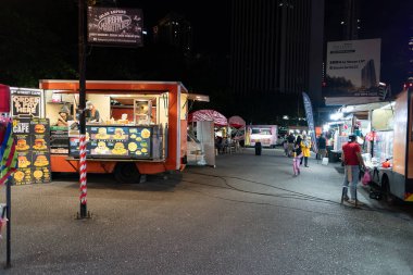 KUALA LUMPUR, MALAYSIA - 02 Aralık 2023: Kuala Lumpur 'da çeşitli yiyecek sağlayıcıları tarafından sunulan hareketli bir yer olan Tapak Yemek Kamyonu Parkı' nın sokak manzarası.