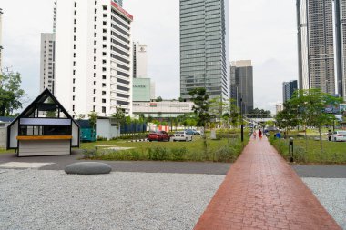 KUALA LUMPUR, MALAYSIA - DECEMBER 03, 2023: street level view of landscaped area with cafes in the outdoor area of Ampang Park MRT Station. clipart