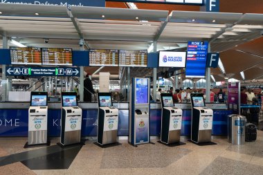 KUALA LUMPUR, MALAYSIA - 03 ARALIK 2023 KLIA 'DA kendi kendini kontrol eden kiosklar. Kişisel kayıt, yolcuların giriş yapmak için kiosk kullandıkları ve kendilerini yazdırdıkları bir süreçtir..