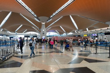 KUALA LUMPUR, MALAYSIA - 03 ARALIK 2023 KLIA kontrol bölgesi. Kayıt işlemlerinde, havayolu personeli ile iletişim halinde olan yolcular belgelerini doğrulamak, bagajlarını kontrol etmek ve uçuş kartı almak için bulunurlar..
