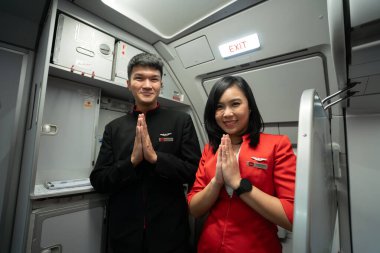 CHIANG MAI, THAILAND - 14 Ekim 2023: üniformalı mürettebat bir AirAsia uçağında inzivaya çekildi.