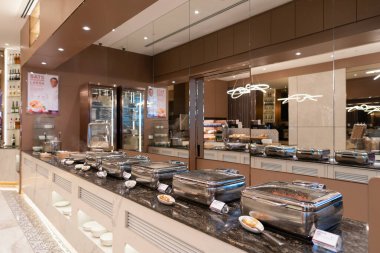 SINGAPORE - 25 AĞUSTOS 2024: Changi Uluslararası Havalimanı 'ndaki SATS Premier Lounge' da açık büfede servis edilen sıcak yemek seçimi.