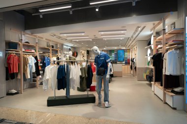 SINGAPORE - 25 AĞUSTOS 2024: Changi Uluslararası Havalimanı 'ndaki Lacoste mağazası mağaza vitrinlerinde çeşitli şık kıyafetler, ayakkabılar ve aksesuarlar sergilenmektedir..