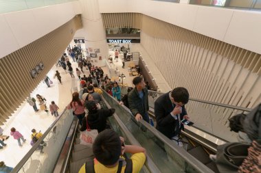 Hong Kong 'da bir alışveriş merkezinde yürüyen merdivene binen insanlar HONG KONG, Çin - Şubat 01, 2019.
