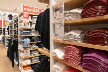 Shenzhen, Çin - Şubat 06, 2019: Giysiler UpperHills alışveriş merkezindeki Uniqlo mağazasında sergileniyor. Uniqlo, erkek, kadın ve çocuklara giysi ve aksesuar sunan bir Japon markasıdır..