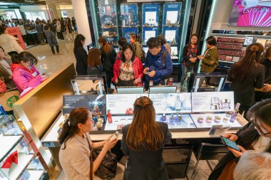 Hong Kong, China - February 02, 2019: customers browsing cosmetic products in a retail area at Harbour City, Hong Kong. clipart