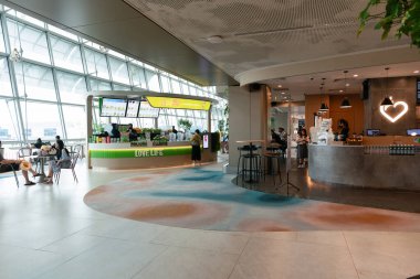 SINGAPORE - 25 AĞUSTOS 2024: Hudsons Coffee ve Boost Juice gibi çeşitli lokantaların yer aldığı Changi Havalimanı 'nın ulaşım bölgesindeki ahır tarzı bölge.