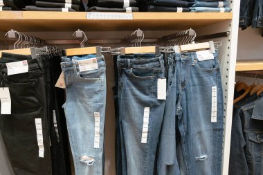 Shenzhen, Çin - Şubat 06, 2019: UpperHills alışveriş merkezindeki Uniqlo mağazasında kot pantolon sergileniyor. Uniqlo, erkek, kadın ve çocuklara giysi ve aksesuar sunan bir Japon markasıdır..