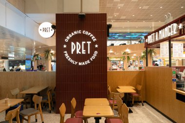 SINGAPORE - 25 AĞUSTOS 2024: Changi Havalimanı Pret a Manger 'da oturma alanı, müşteri kullanımı için masa ve sandalyelerle donatılmış.