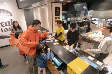Hong Kong 'da bir McDonald' s restoranında müşteriler ya yemek siparişi veriyor ya da alıyorlardı..