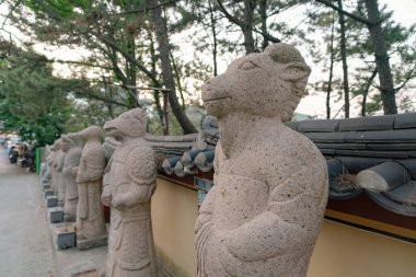 Busan, Güney Kore - 25 Mayıs 2017: Haedong Yonggung Tapınağında görülen bir dizi zodyak hayvan füjleri.