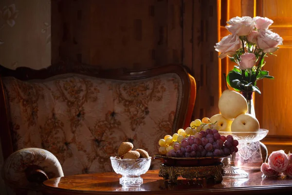 静谧的生活 花瓶里有花 桌子上有水果 背景上有椅子 — 图库照片