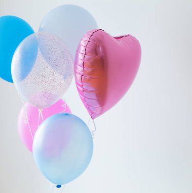 Beyaz arkaplanda mavi ve pembe balonlar