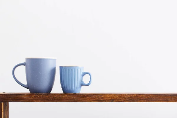 Twee Blauwe Kopjes Houten Plank Witte Achtergrond — Stockfoto