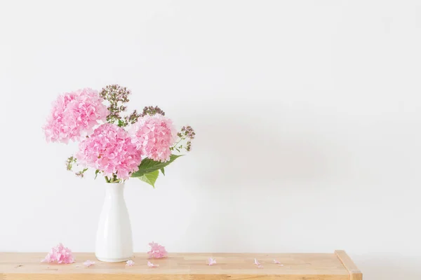 背景の白い壁に白い花瓶にピンクのアジサイ — ストック写真