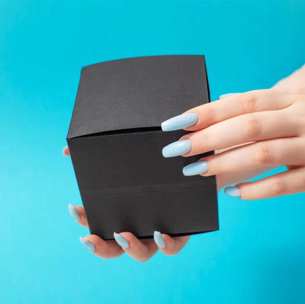 Vrouwelijke Hand Met Zwarte Geschenkdoos Blauwe Achtergrond — Stockfoto
