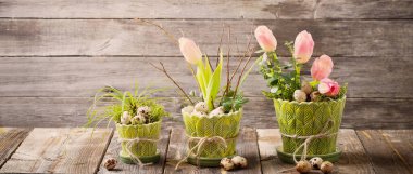 Ahşap arka planda yumurta ve çiçeklerle paskalya kompozisyonu 