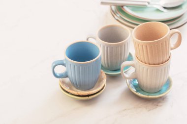 seramik bardaklar ve tabaklar beyaz mermer masa üzerinde