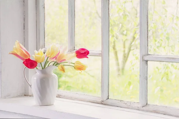 漂亮的郁金香插在白色窗台上的花瓶里 — 图库照片