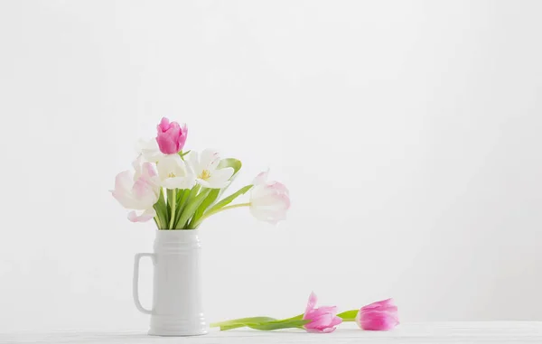 白色背景的水壶中的白色和粉色郁金香 — 图库照片