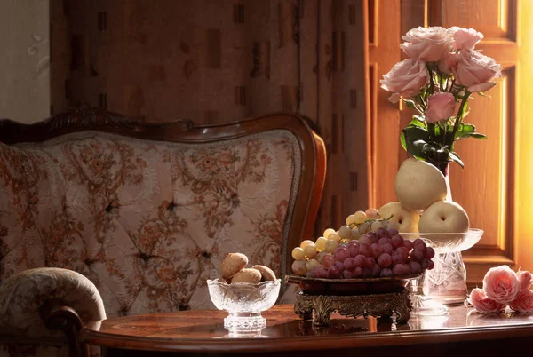 静谧的生活 花瓶里有花 桌子上有水果 背景上有椅子 — 图库照片