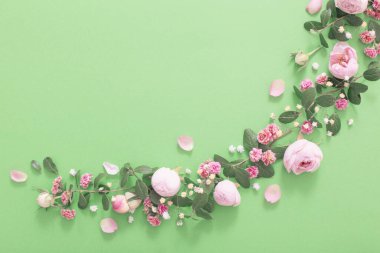 Yeşil arka planda pembe çiçekler ve yeşil yapraklar