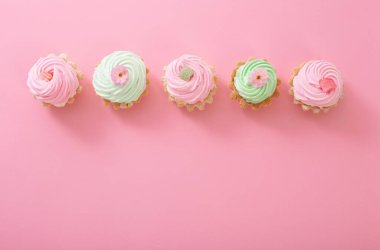 Pembe arka planda pembe ve yeşil kekler