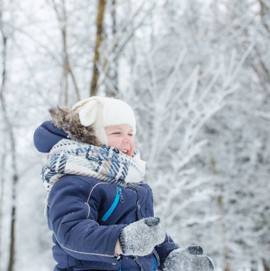 Karlı kış parkında küçük mutlu çocuk