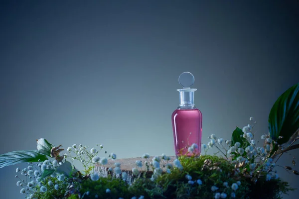 Magiczny Eliksir Szklanej Butelce Roślinami Kwiatami Niebieskim Tle — Zdjęcie stockowe