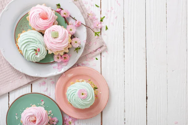 Rosa Und Grüne Cupcakes Mit Frühlingsblumen Auf Weißem Holzhintergrund — Stockfoto