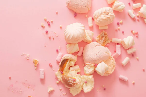 粉红背景上掉落和破碎的糖果 — 图库照片