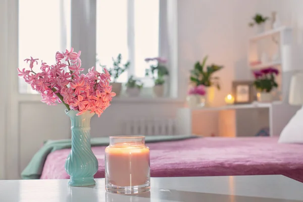 pink and white interior of bedroom with spring flowers