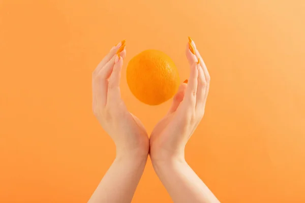 Weibliche Hand Mit Orange Auf Orangefarbenem Hintergrund — Stockfoto