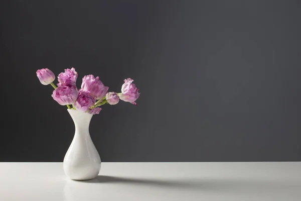 Fioletowe Tulipany Białym Wazonie Tle Szarej Ściany — Zdjęcie stockowe