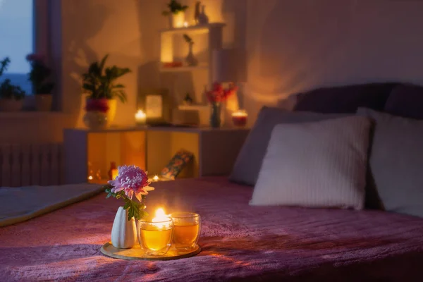 花とお茶と夜の居心地の良いベッドルーム — ストック写真