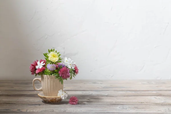 Flores Bonitas Copo Mesa Madeira Fundo Parede Branca — Fotografia de Stock