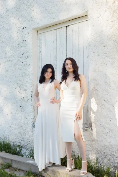 Дві Молоді Дівчата Білій Сукні Фоні Старої Білої Стіни — стокове фото