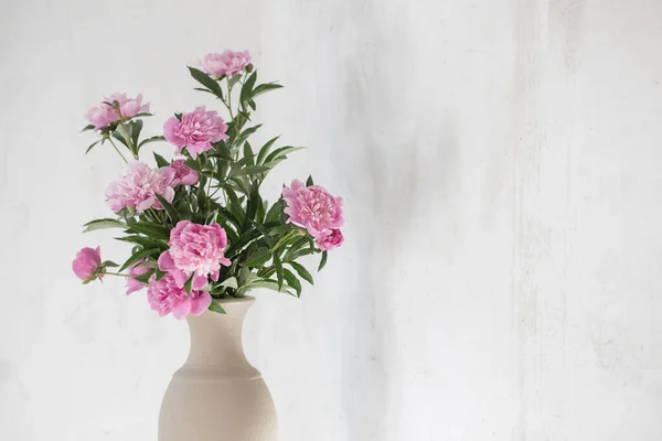 背景にある陶器の花瓶にピンクの牡丹古い壁 — ストック写真