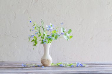 Vazodaki yabani çiçekler arka plandaki beyaz eski duvarda