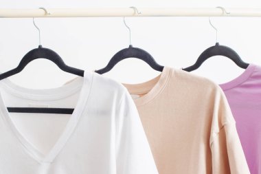 Beyaz arka planda asılı kadın tişörtleri