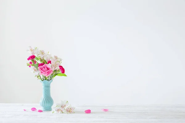 蓝色花瓶中的粉红色和白色花 背景为白色 — 图库照片