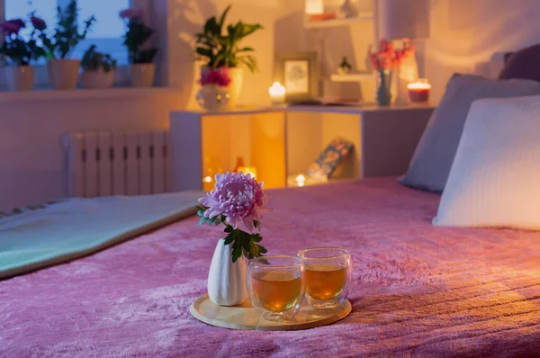 花とお茶と夜の居心地の良いベッドルーム — ストック写真